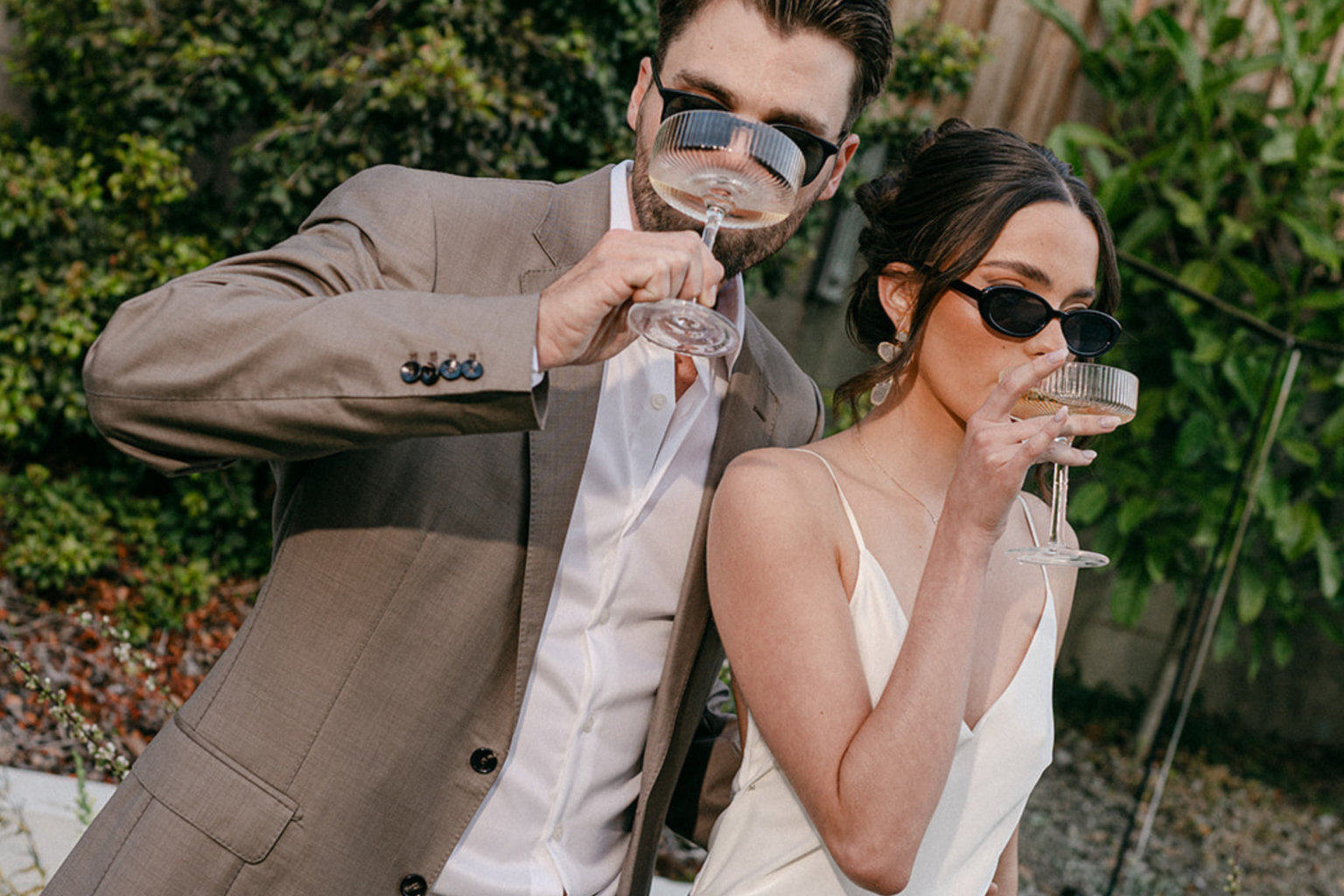 Stylish couple in sunglasses sipping champagne
