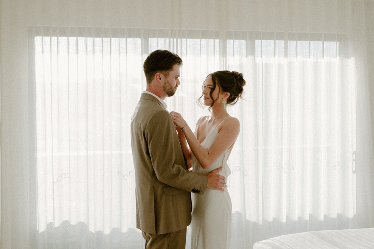 Couple embracing by the window in an Ocean Deck Suite