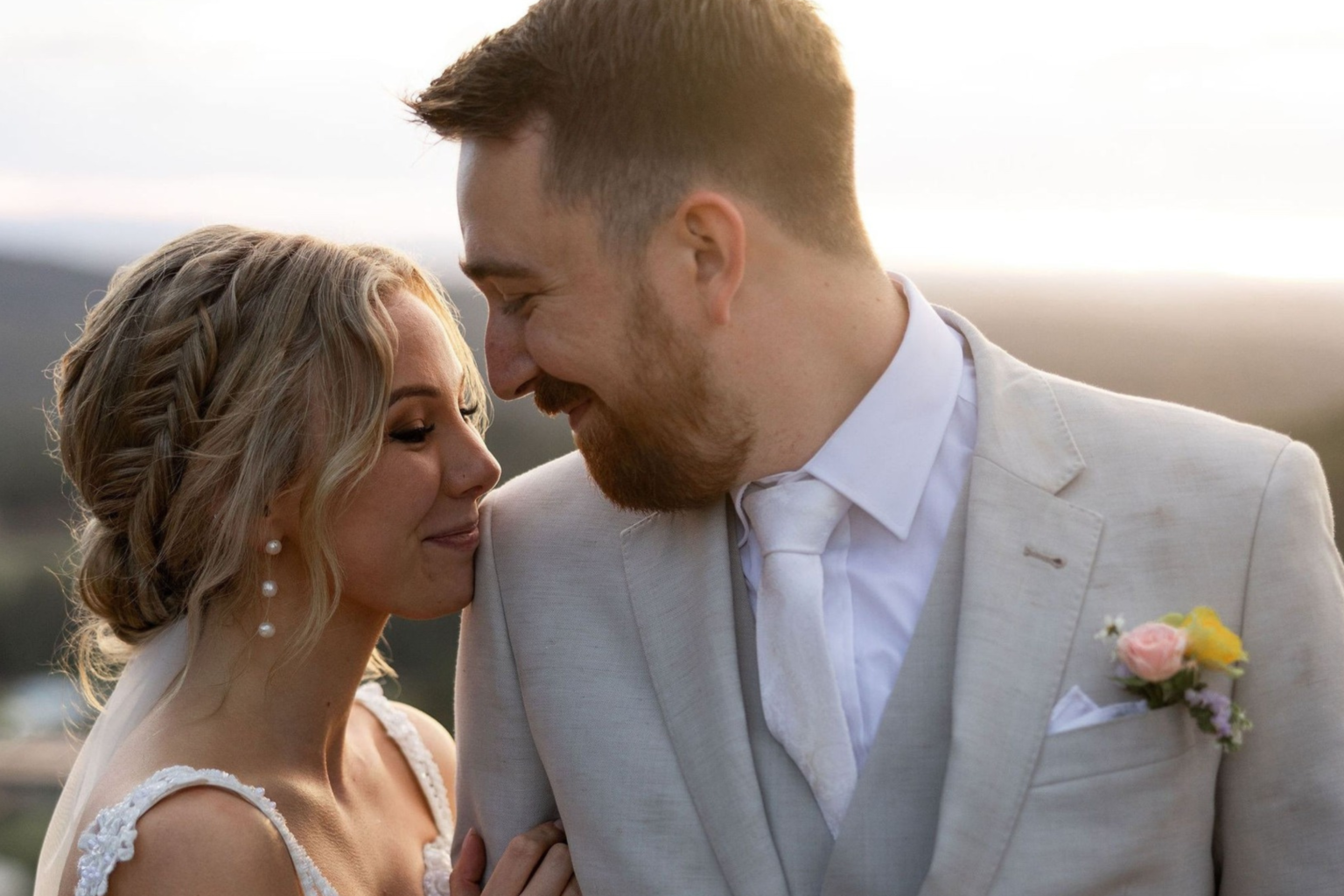 Bride and groom smiling close together at golden hour