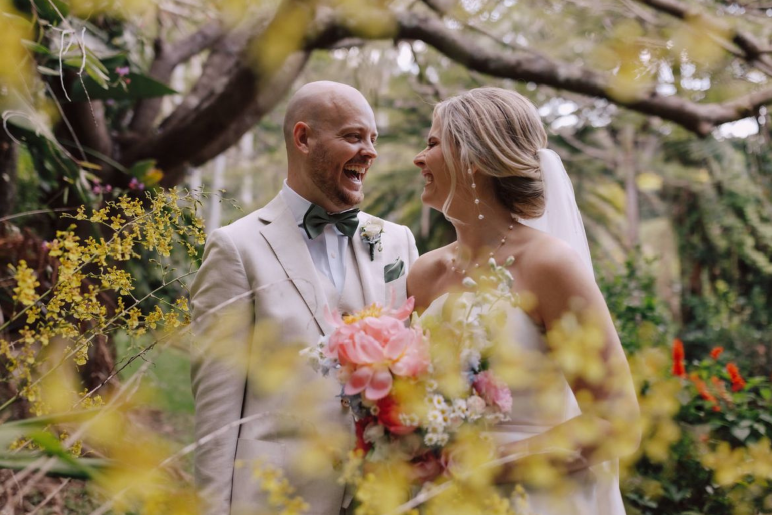 Couple laughing among yellow blooms at Rainforest Gardens