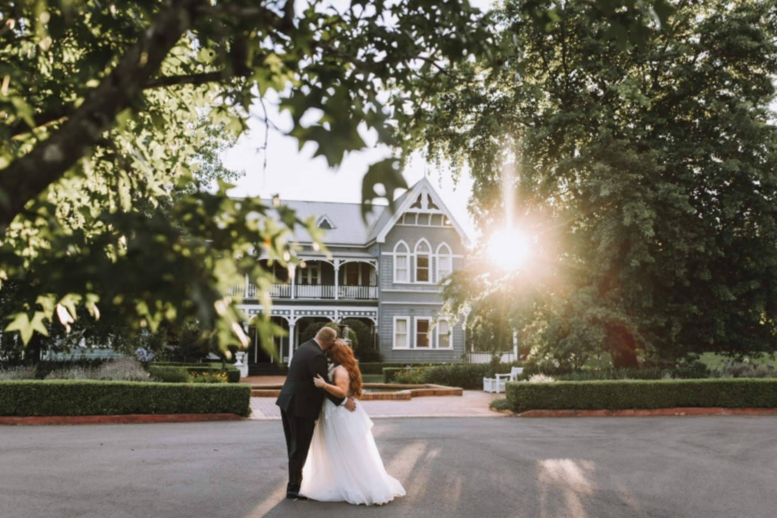 Bride and groom kissing in the sunlit driveway at The Convent Hunter Valley