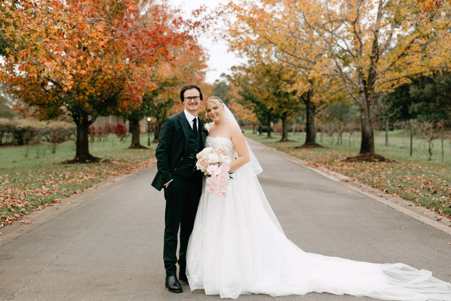 Couple beneath autumn trees on the drive at The Convent