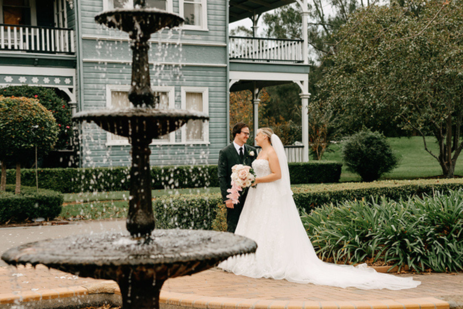 Couple embracing beside the tiered fountain at The Convent