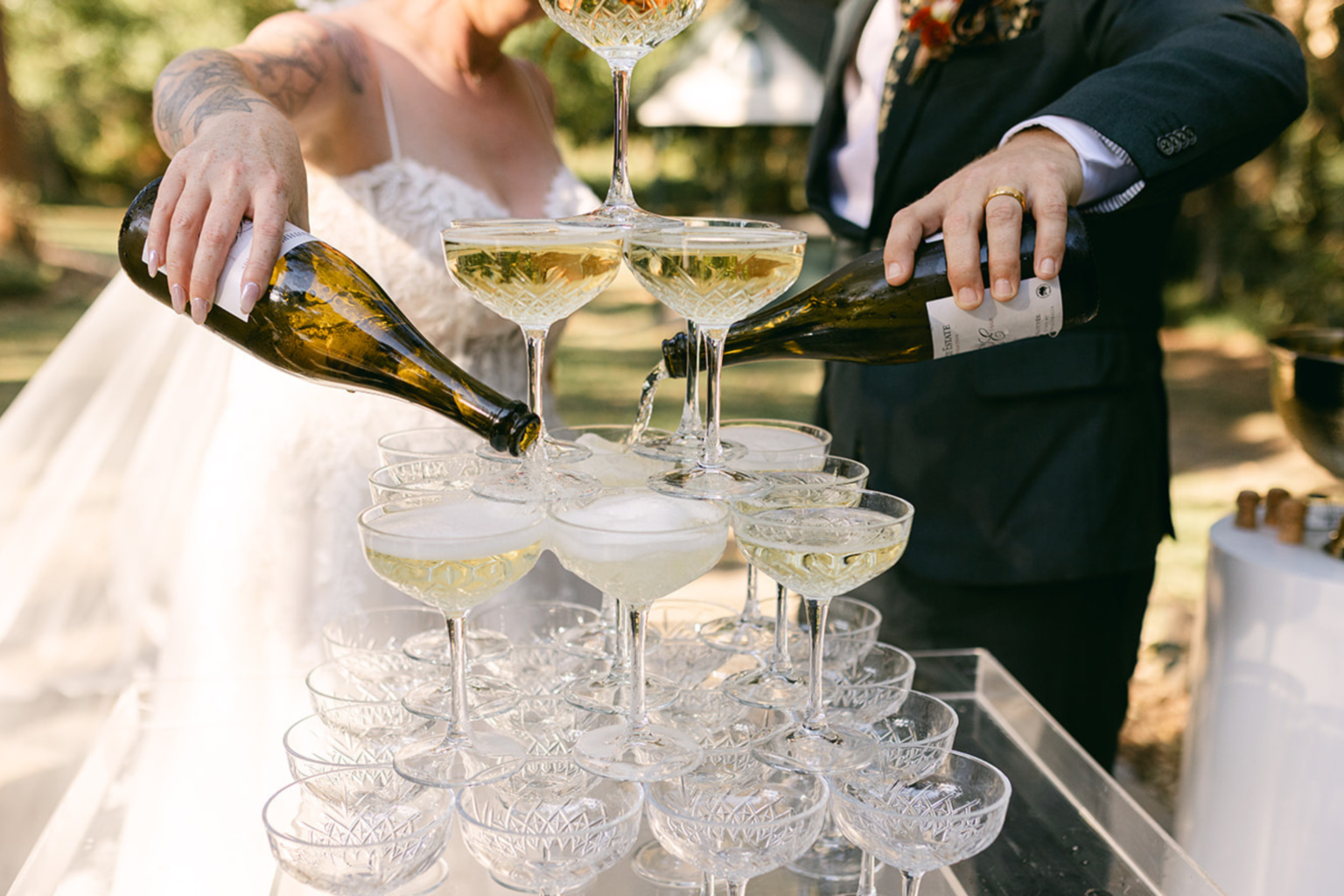 Couple pouring champagne into a coupe tower