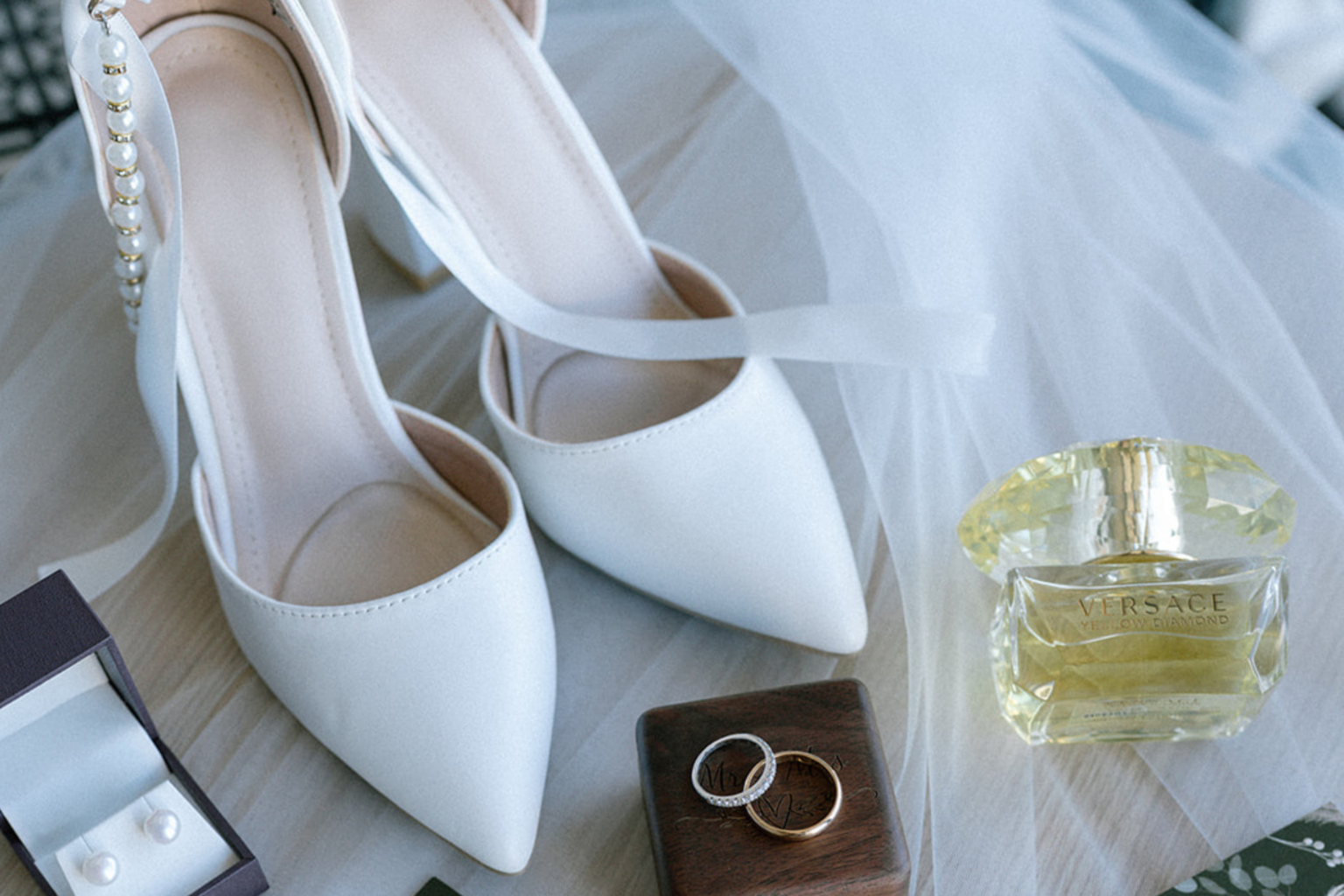 Bridal shoes, rings and perfume flat lay