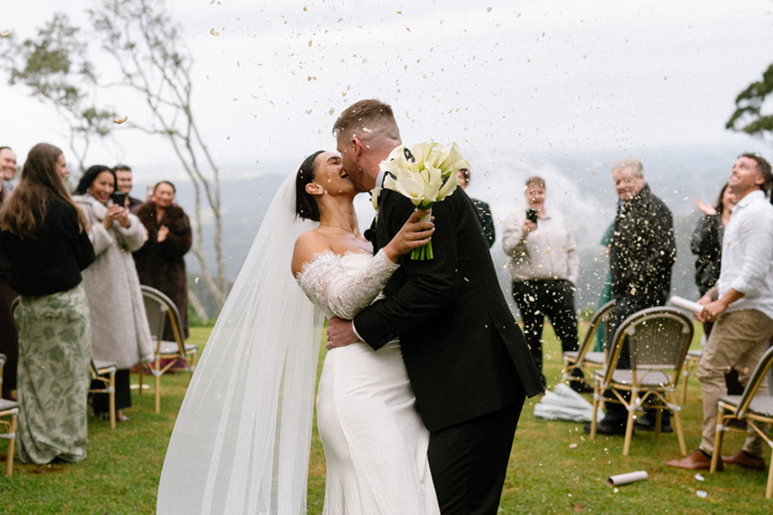 Couple kissing as guests cheer after the ceremony