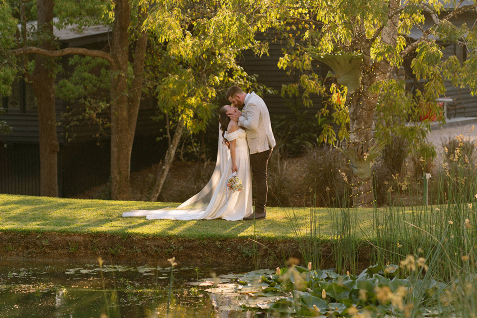 Couple kissing beside the lily pond at golden hour