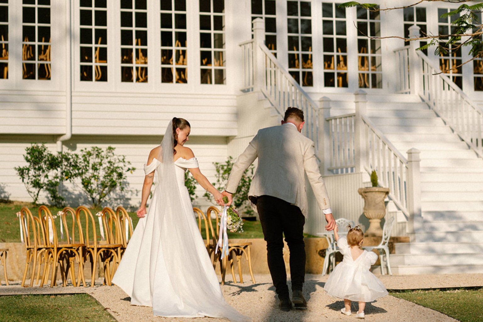 Couple walking past the ceremony chairs toward the staircase