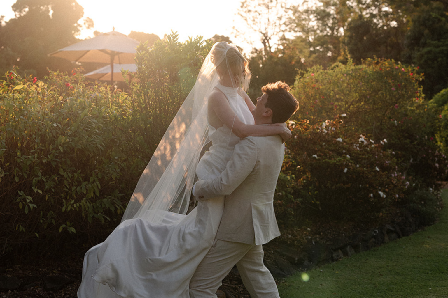 Groom lifting the bride in golden light