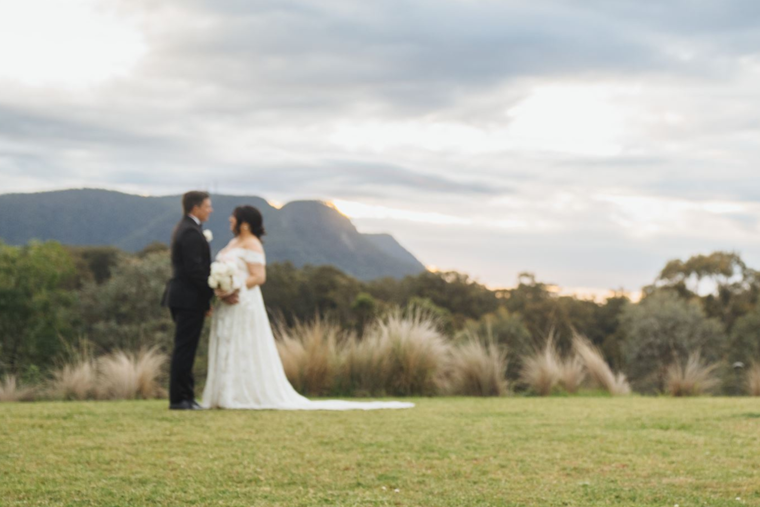 Couple facing each other on the lawn with mountain views, Hunter Valley