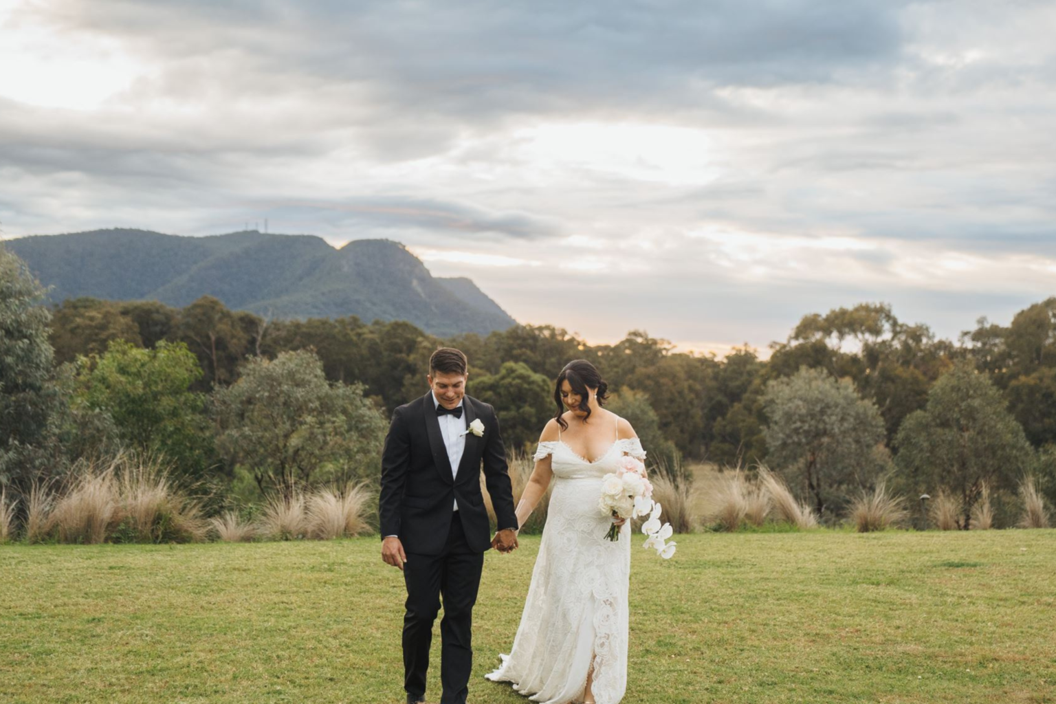 Bride and groom walking together below the Brokenback Range