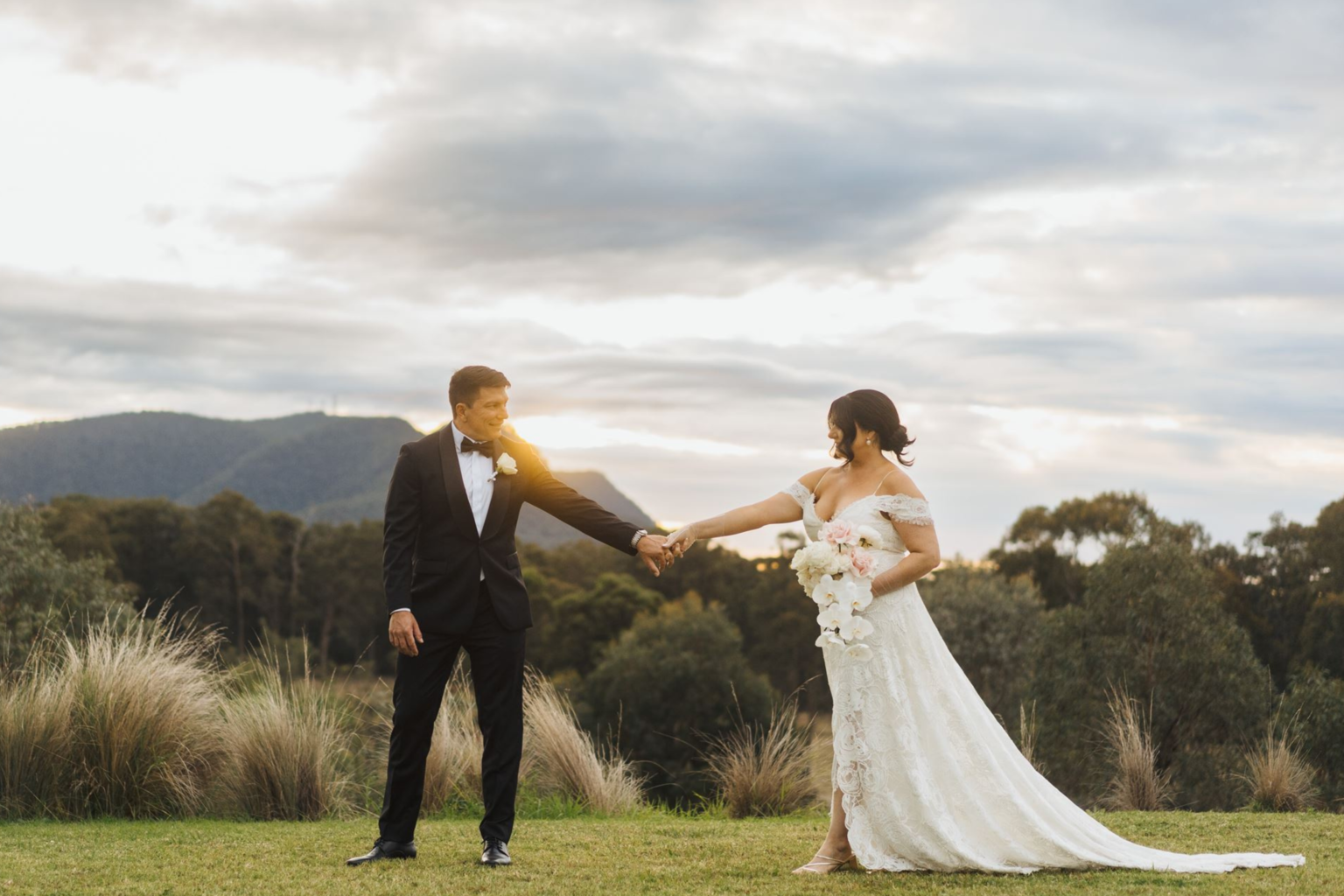 Groom leading the bride across the lawn by the hand