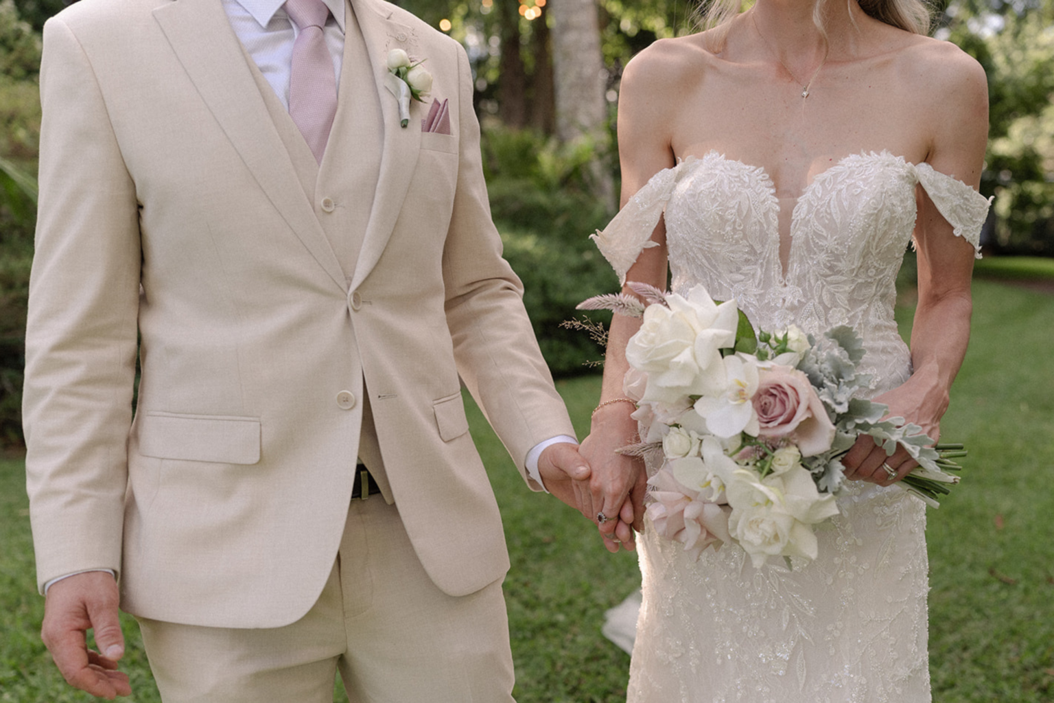 Couple holding hands, bride holding a pastel bouquet