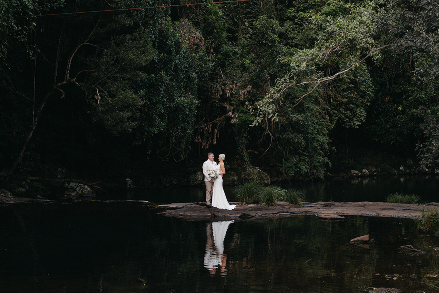 Couple reflected in the rainforest rock pool