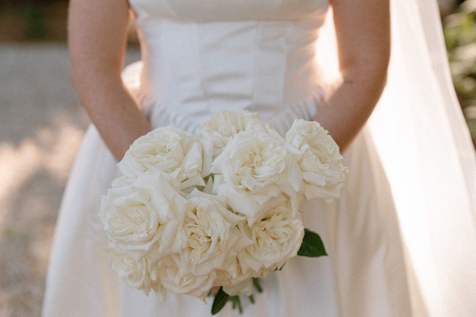 Bride holding a bouquet of white roses