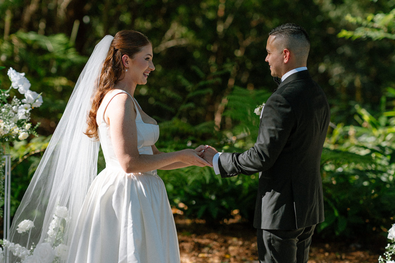 Bride and groom holding hands during their vows