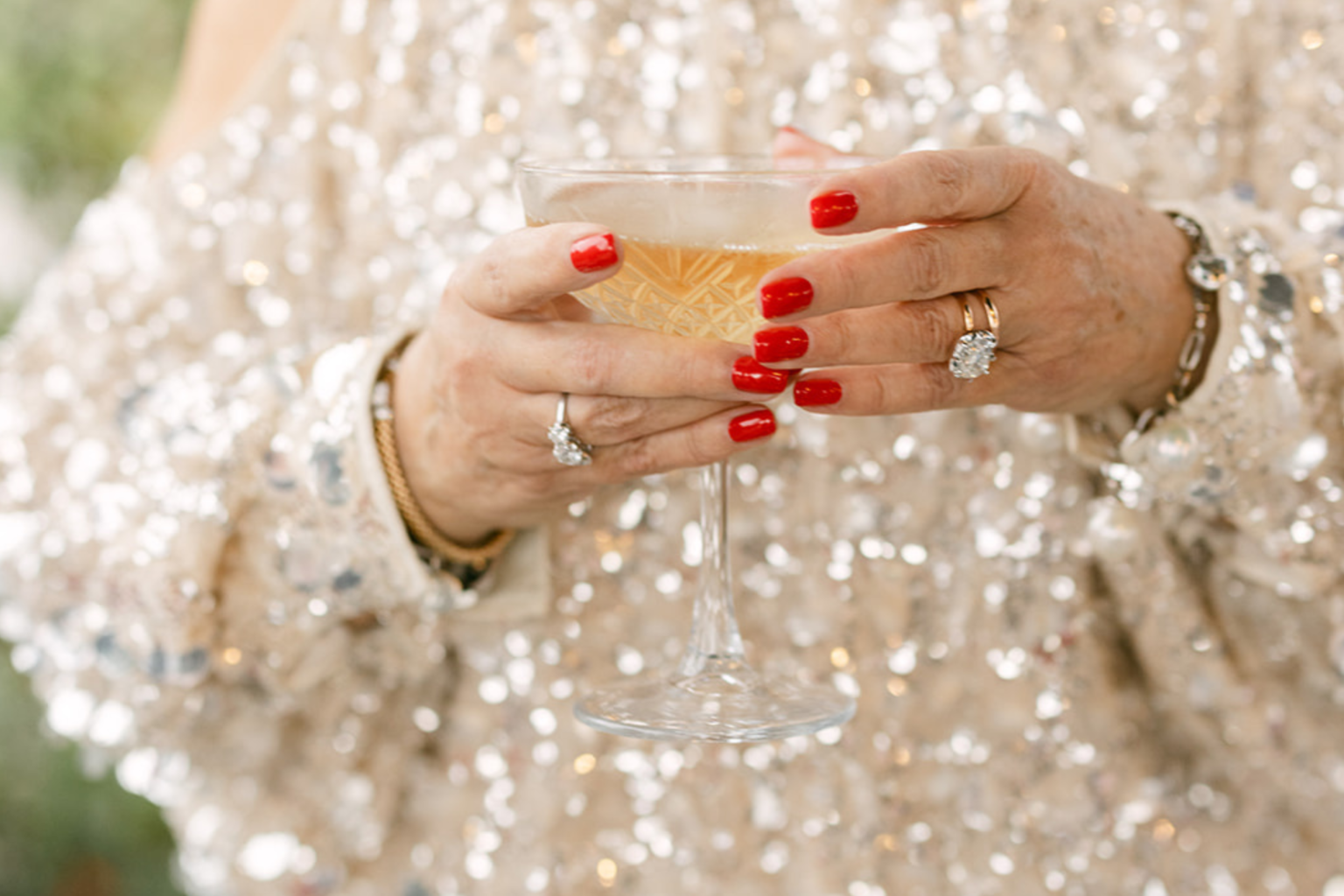 Guest in a sequined jacket holding a glass of champagne