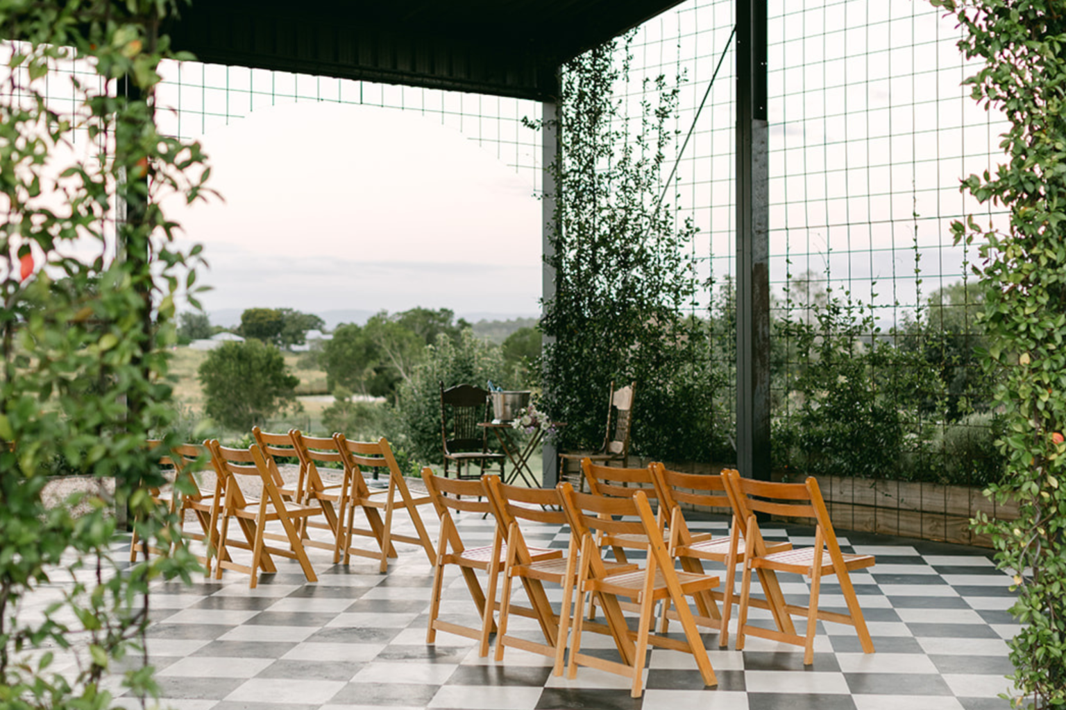 Timber ceremony chairs on the checkerboard floor of the Conservatory